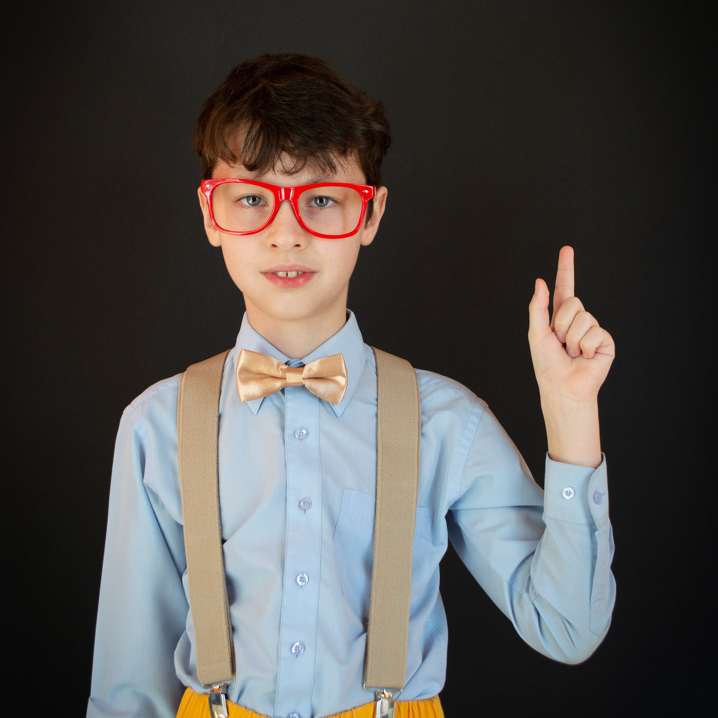 young boy in red glasses with a question