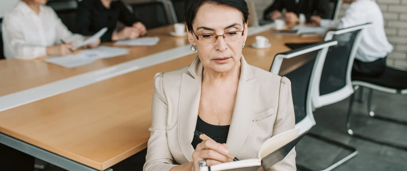 Woman reviewing notes at a professional meeting