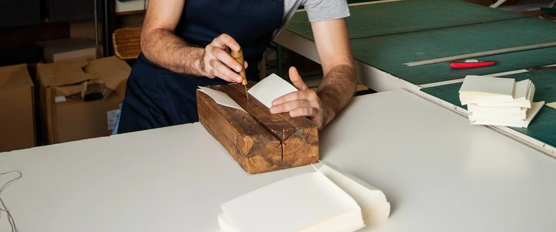 Guy binding a book in a workshop