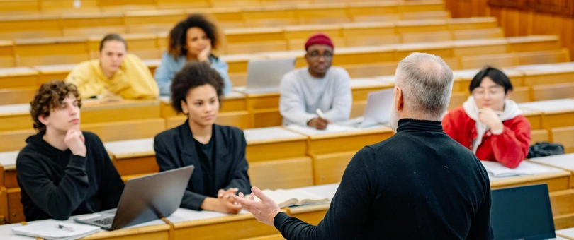man teaching students in university