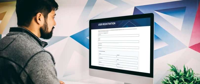Man looking at computer screen with user registration form